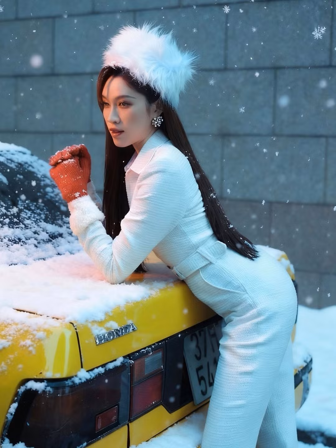 Điểm đặc biệt khiến bộ ảnh trở nên thu hút chính là sự xuất hiện của chiếc xe cổ màu vàng nổi bật. Sự kết hợp giữa màu trắng của tuyết, màu vàng của xe và sắc đỏ của phụ kiện tạo nên một tổng thể màu sắc nịnh mắt, mang hơi hướng cổ điển của những thập niên trước. (Ảnh: IGNV)