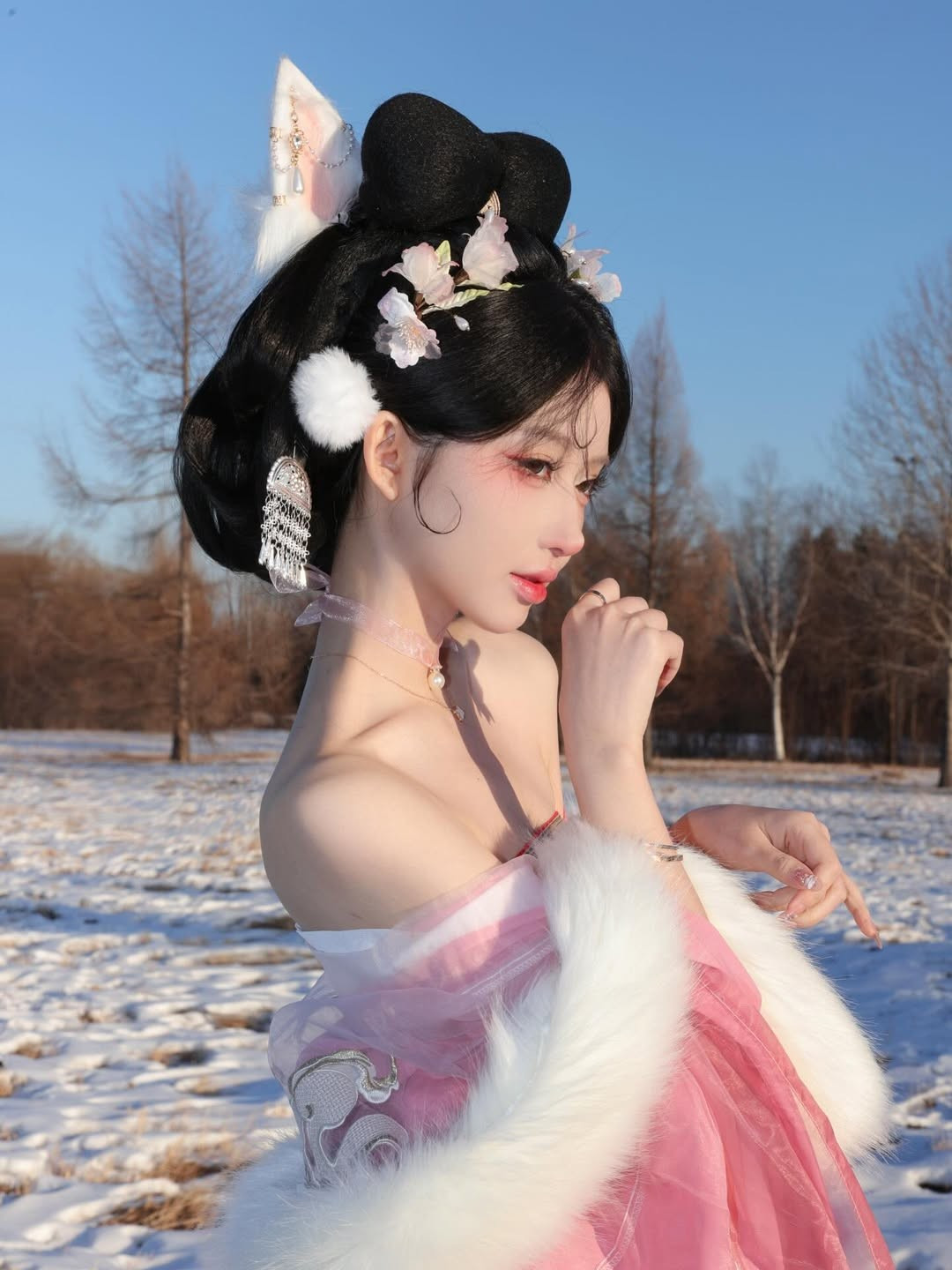 Điểm nhấn không thể bỏ qua là mái tóc búi cầu kỳ, cài nhiều hoa trắng, ngọc trai và đặc biệt là chiếc tai hồ ly màu trắng tinh tế, mang nét kiều mị. (Ảnh: IGNV)