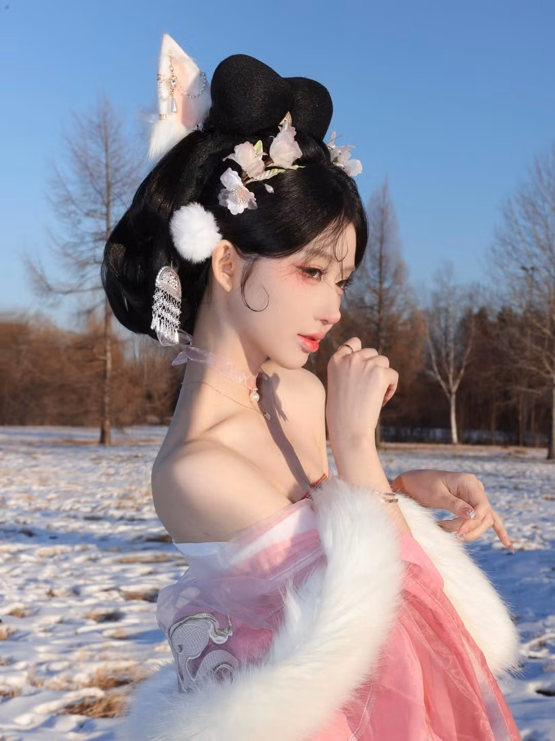 Điểm nhấn không thể bỏ qua là mái tóc búi cầu kỳ, cài nhiều hoa trắng, ngọc trai và đặc biệt là chiếc tai hồ ly màu trắng tinh tế, mang nét kiều mị. (Ảnh: IGNV)