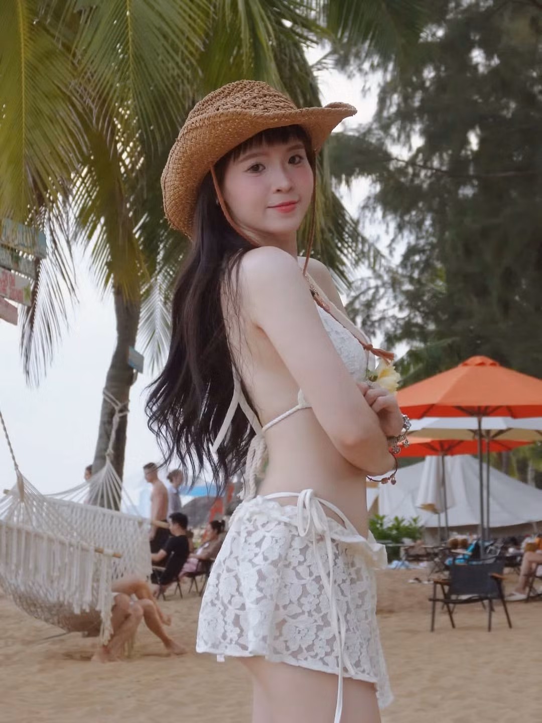 Trong bối cảnh bãi biển lãng mạn, Thúy Kiều diện bộ bikini trắng kem với những chi tiết ren tinh xảo, tạo nên vẻ ngoài vừa gợi cảm, vừa thanh thoát. Chiếc mũ cói rộng vành không chỉ là điểm nhấn thời trang mà còn tăng thêm nét dịu dàng, nữ tính cho cô. (Ảnh: IGNV)