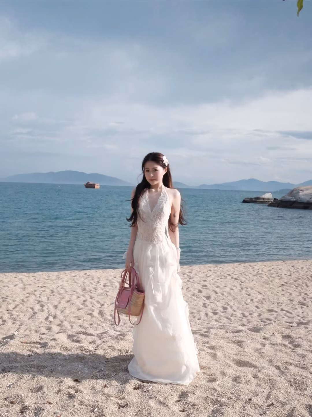 Chiếc váy trắng dáng dài với thiết kế hở lưng trần giúp Chao toát lên vẻ thanh thoát, nhẹ nhàng giữa không gian bao la của biển cả. Dưới ánh nắng hoàng hôn, cô nàng rảo bước toát lên khí chất tiểu thư đài các. (Ảnh: IGNV)