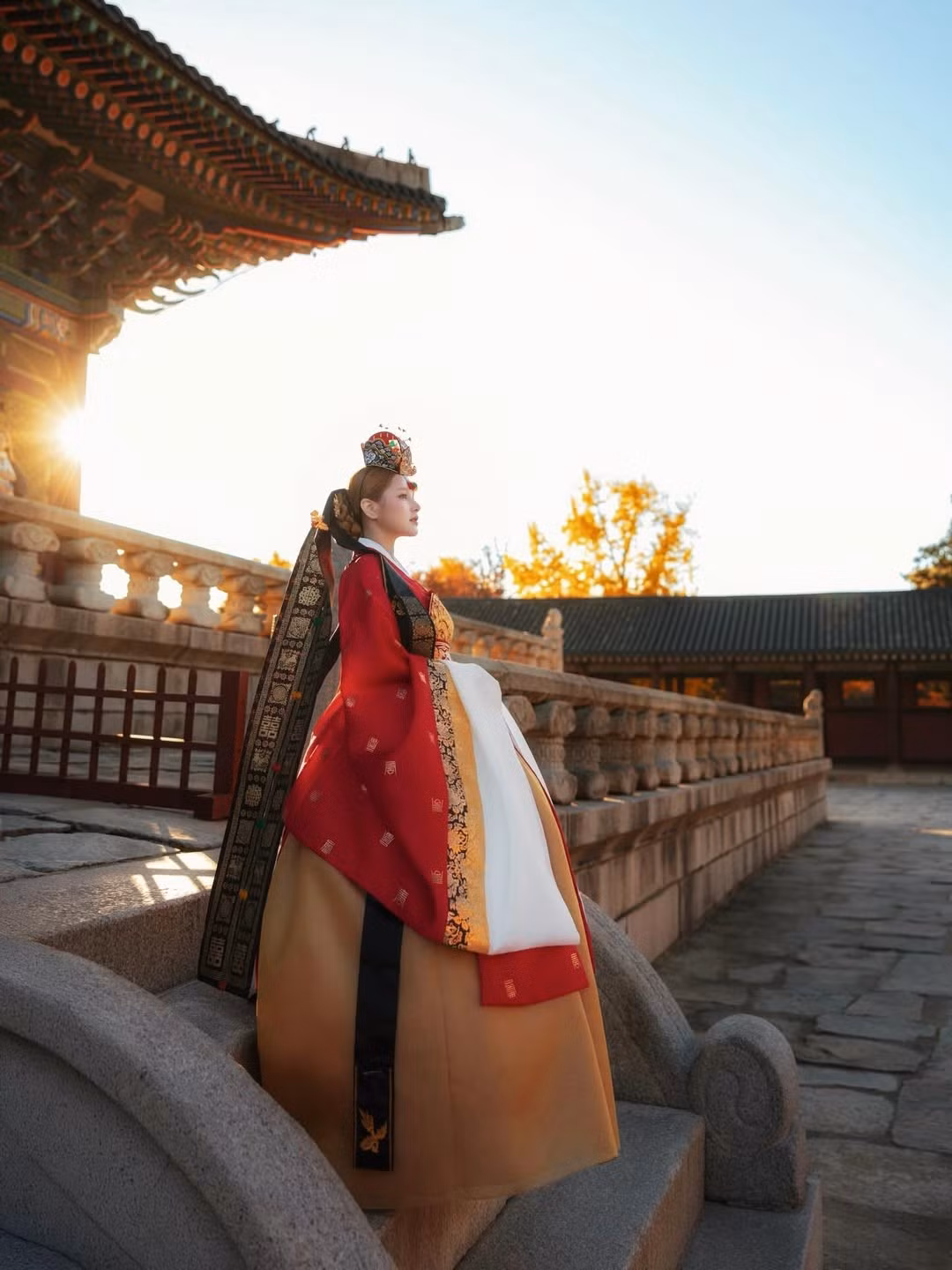 Ánh nắng rực rỡ chiếu rọi qua các cây cột son đỏ, hòa quyện với màu Hanbok khiến bức hình trở nên có chiều sâu và ấn tượng. (Ảnh: IGNV)