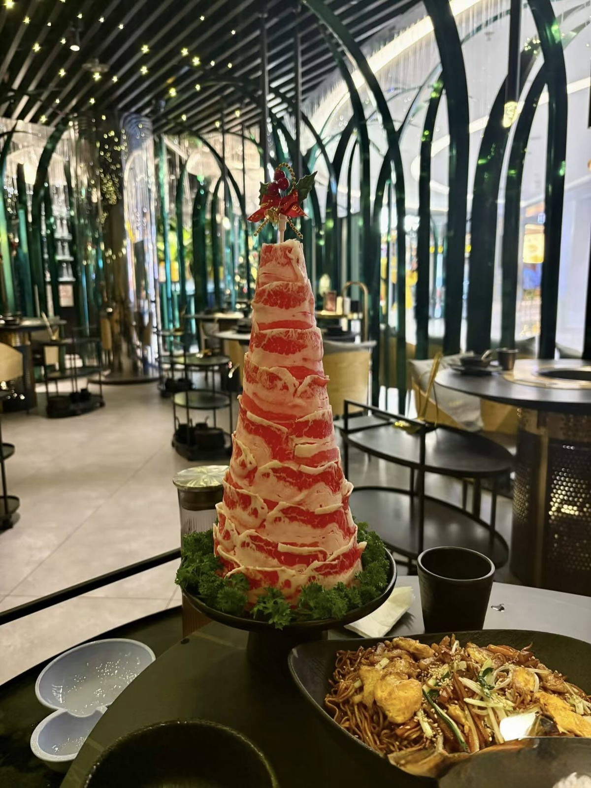 Với những lát thịt tươi được cuộn và xếp chồng lên nhau trong nhà hàng lẩu, cây thông này tạo nên một điểm nhấn sang trọng và ấn tượng, như một "tháp" nguyên liệu hấp dẫn.