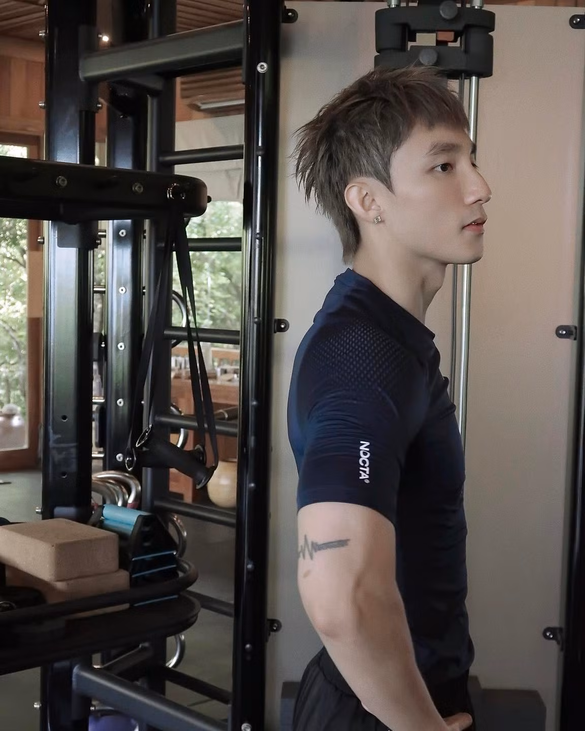 Sơn Tùng diện áo ôm sát khoe trọn bắp tay rắn chắc và phần vai nở rộng, kết hợp với tư thế gồng người trong lúc nâng tạ hay tập luyện với dây kháng lực.