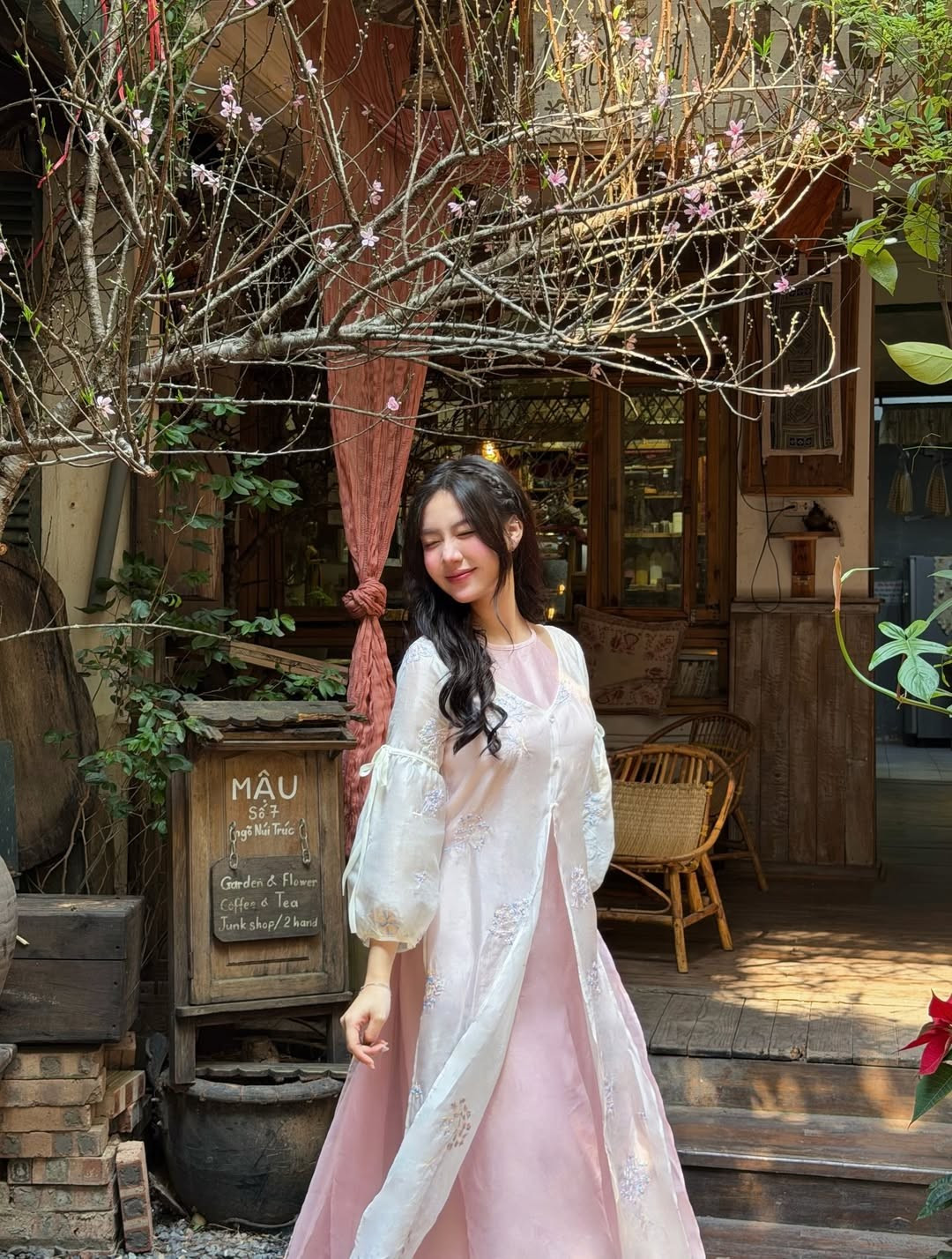 Trong bộ ảnh này, cô nàng lựa chọn thiết kế áo dài cách tân nhiều lớp với tông màu hồng phấn và trắng chủ đạo. Chất liệu voan tơ mềm mại phối cùng các chi tiết thêu hoa nhí tinh tế giúp tôn lên làn da trắng sứ và vóc dáng mảnh mai của nàng hot girl. (Ảnh: IGNV)