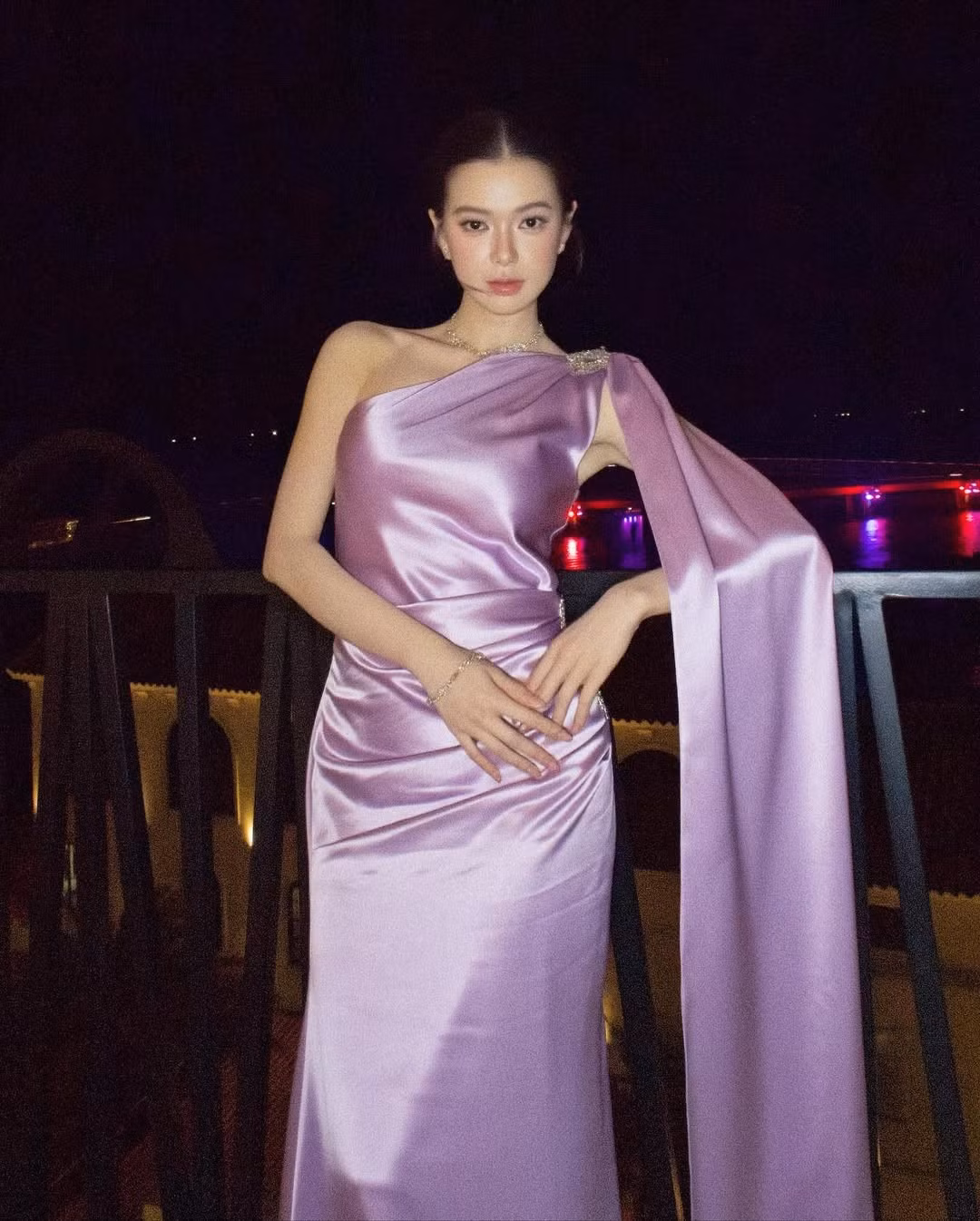 Đầm có kiểu dáng một vai kết hợp cùng chi tiết tà áo choàng dài, rủ từ vai xuống. Thiết kế này không chỉ tôn lên bờ vai thon thả mà còn tạo cảm giác bí ẩn, quý phái, khiến cô trông như một nữ thần bước ra từ thần thoại. (Ảnh: IGNV)