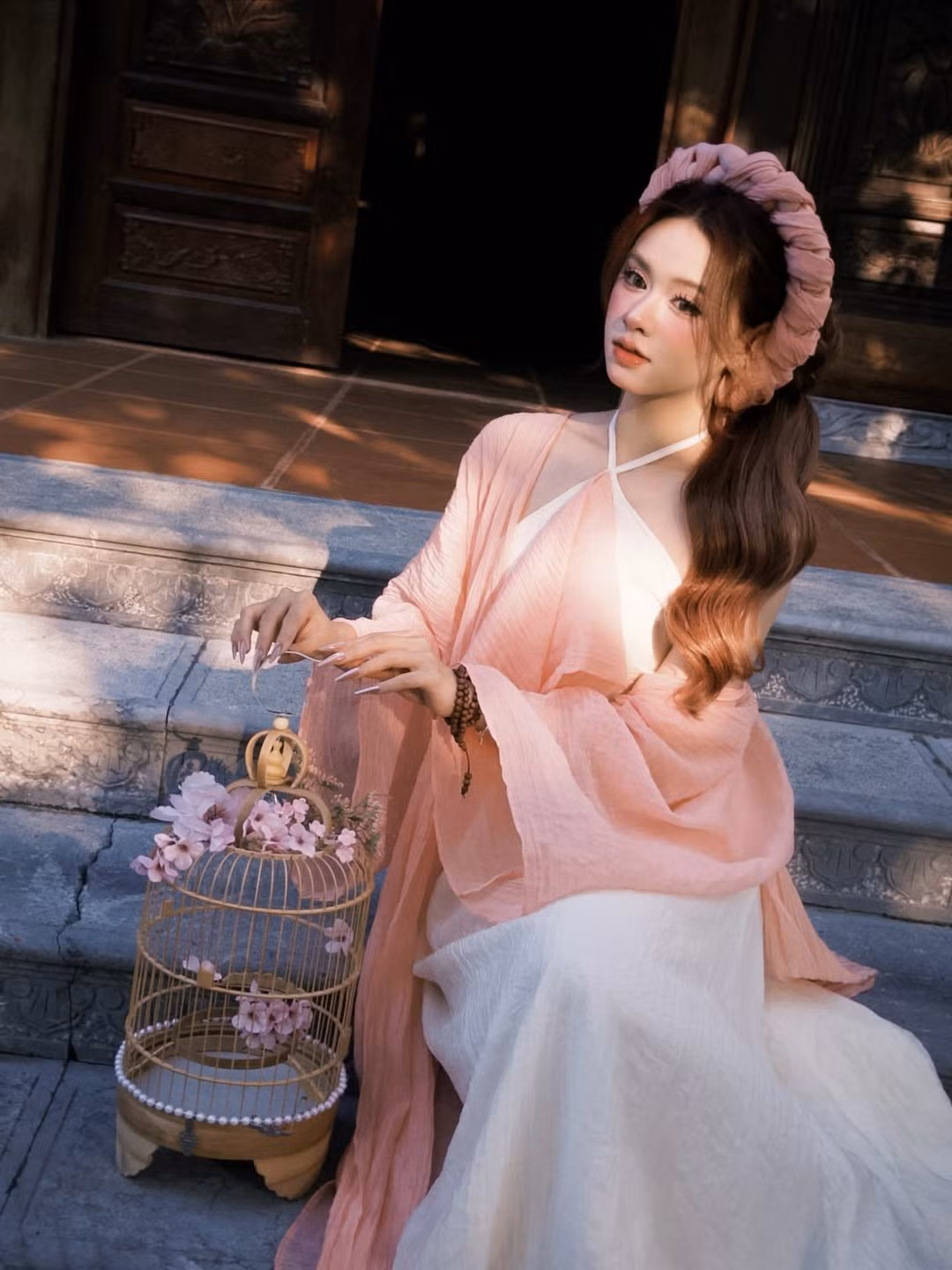 Chiếc mấn đội đầu tết bản to cùng tông hồng không chỉ tôn lên gương mặt thanh tú mà còn tạo nên vẻ đài các, cổ điển như những nàng tiểu thư trong các gia đình quyền quý xưa. (Ảnh: IGNV)