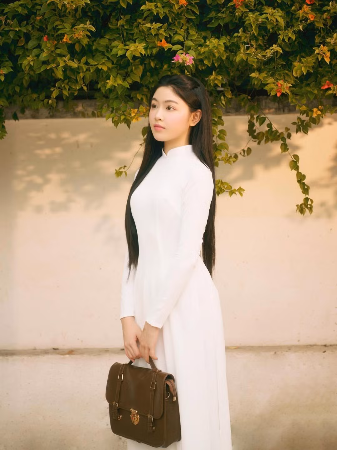 Trong loạt ảnh mới, Lọ Lem xuất hiện với tà áo dài trắng tay dài truyền thống, khiến người nhìn liên tưởng đến vẻ đẹp nữ sinh Việt Nam. Trang phục không cầu kỳ nhưng lại làm nổi bật hoàn hảo vóc dáng cao ráo và nét dịu dàng, đằm thắm của cô bé. (Ảnh: IGNV)