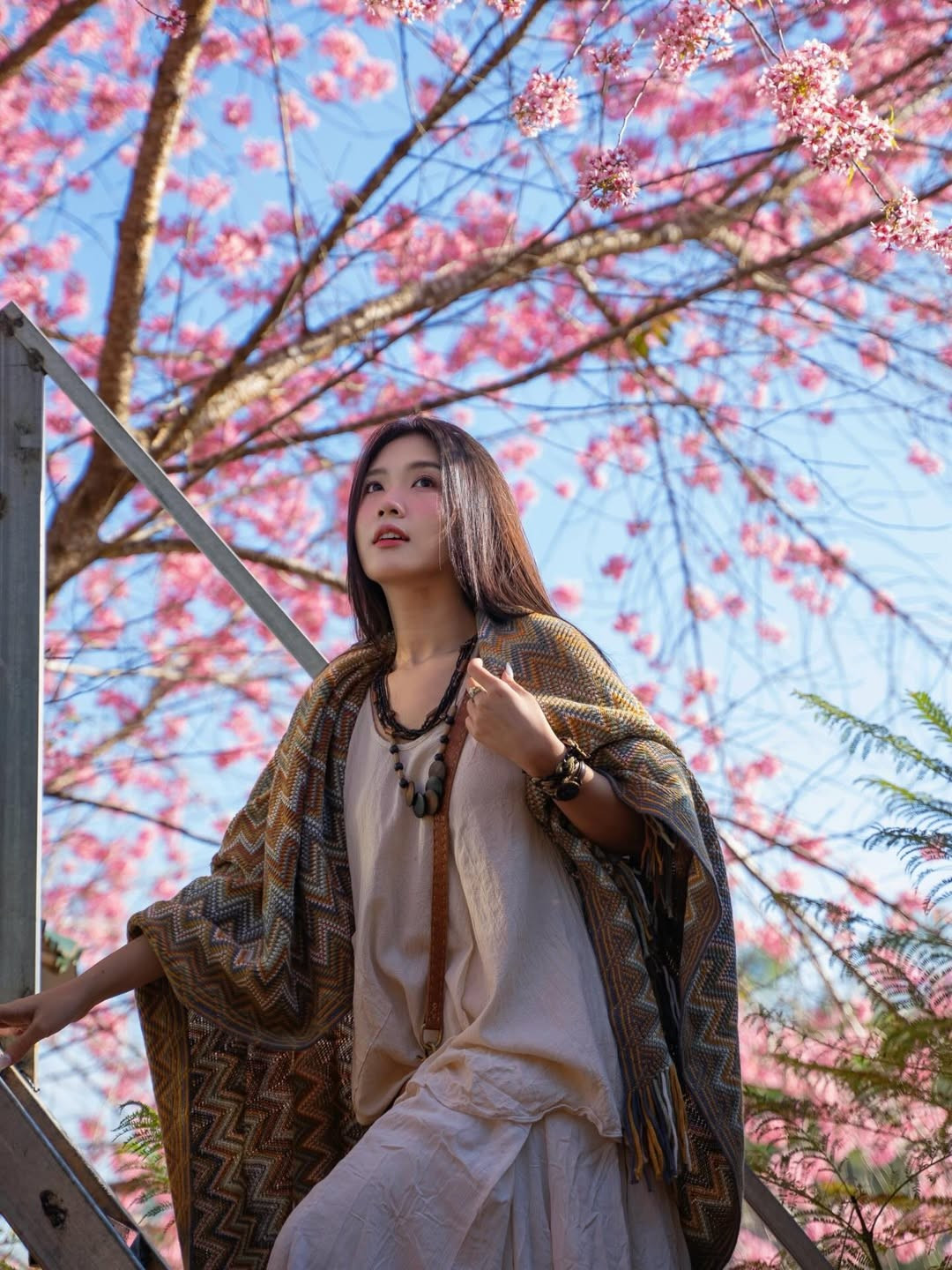 Trong bộ ảnh, Lylychuu lựa chọn trang phục mang hơi hướng Bohemian đầy tự do. Cô kết hợp chiếc váy trắng tinh khôi cùng chiếc khăn choàng họa tiết thổ cẩm tone vàng nâu ấm áp. (Ảnh: IGNV)