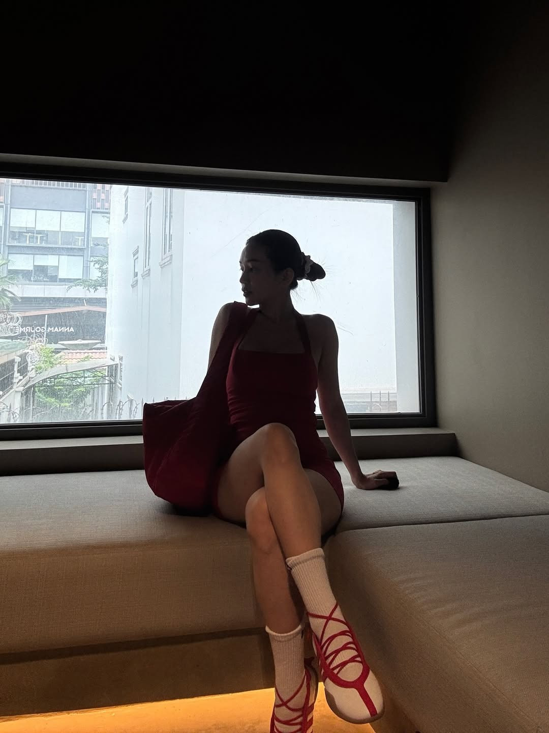 Ở set đồ đầu tiên, cô nàng lựa chọn jumpsuit ngắn màu đỏ nổi bật, kết hợp cùng áo khoác ngoài trắng và đôi giày thể thao buộc dây độc đáo. (Ảnh: IGNV)