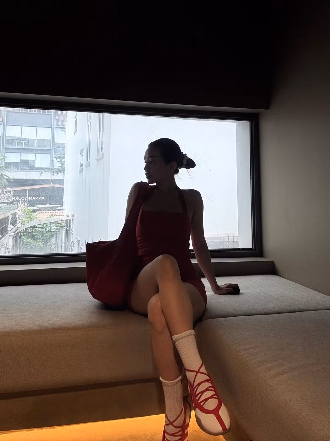 Ở set đồ đầu tiên, cô nàng lựa chọn jumpsuit ngắn màu đỏ nổi bật, kết hợp cùng áo khoác ngoài trắng và đôi giày thể thao buộc dây độc đáo. (Ảnh: IGNV)