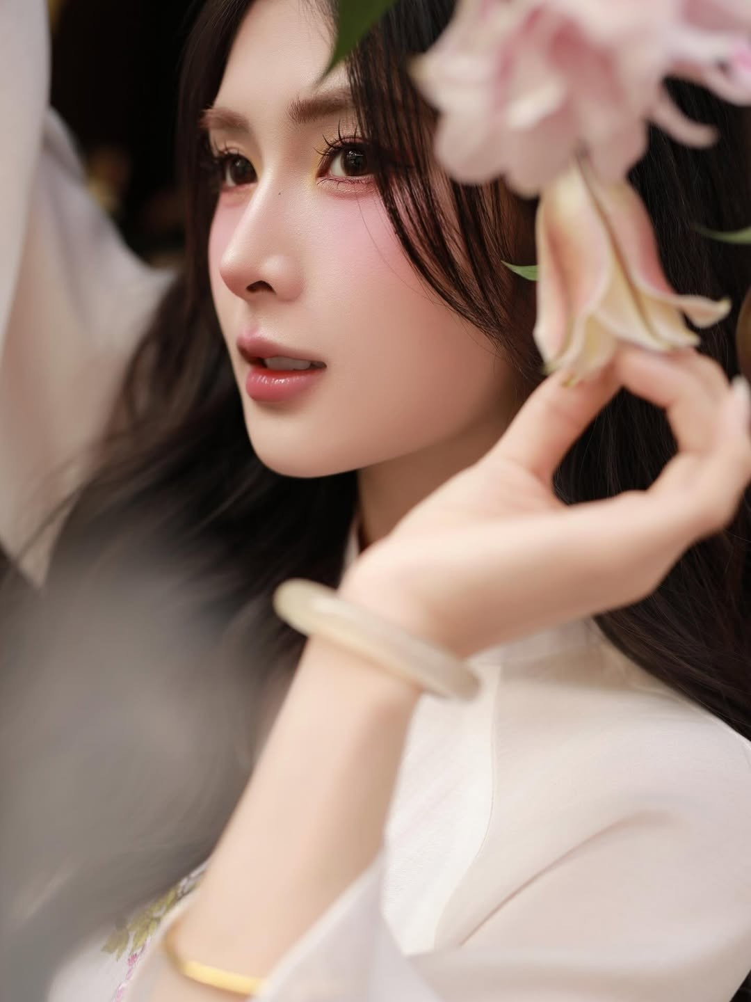 Đặc biệt, mái tóc đen dài được uốn xoăn sóng nước bồng bềnh, để xõa tự nhiên sau lưng kết hợp với phần tóc mái thưa nhẹ nhàng che bớt vầng trán, không chỉ giúp gương mặt trở nên thanh tú hơn mà còn tăng thêm phần nữ tính, đằm thắm. (Ảnh: IGNV)