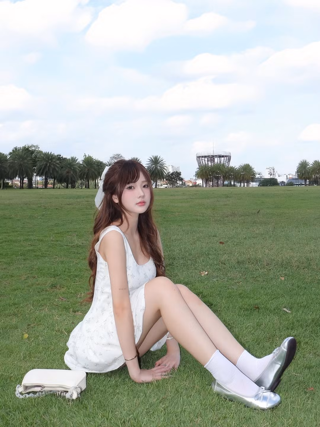 Mái tóc dài, xoăn nhẹ tự nhiên được thả xõa hoặc buộc nửa đầu, kết hợp cùng chiếc nơ trắng xinh xắn, càng làm tăng thêm vẻ đáng yêu, trong sáng.