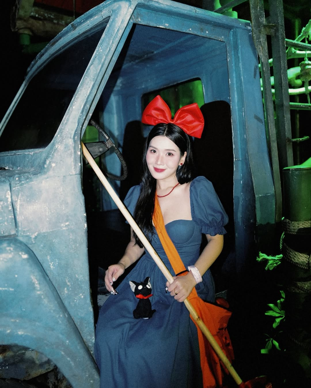 Không thể thiếu cô mèo đen Jiji tinh nghịch, được Chù mang theo mọi lúc mọi nơi. Chiếc túi xách màu cam quá khổ cũng được tái hiện trọn vẹn, gợi nhớ đến công việc giao hàng của phù thủy nhỏ. (Ảnh: FBNV)