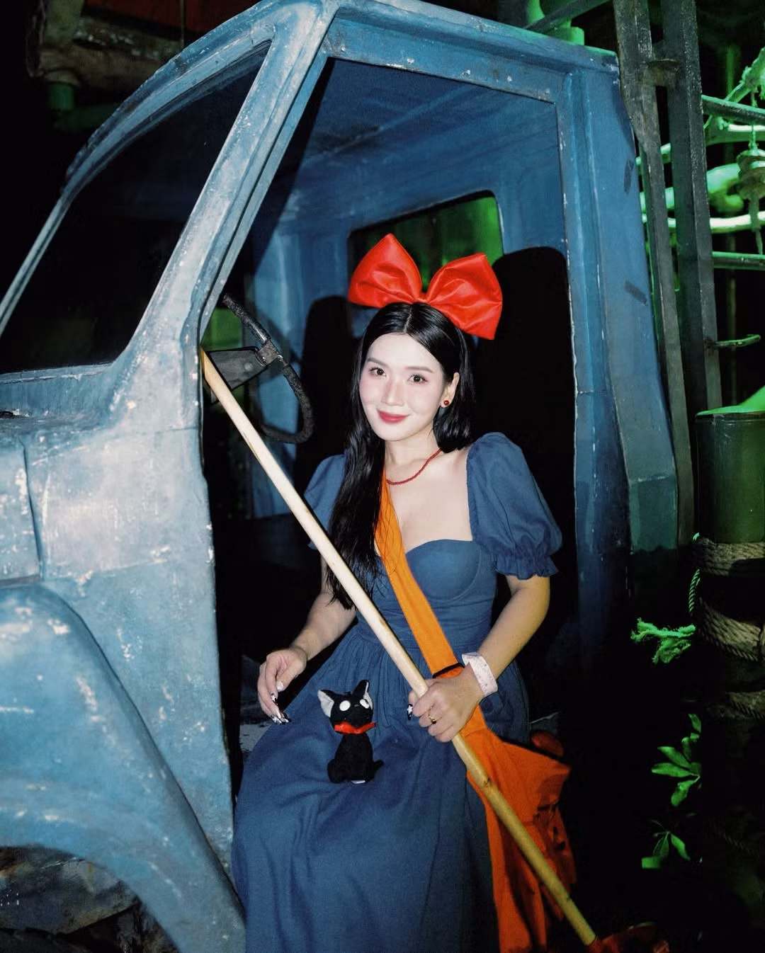 Không thể thiếu cô mèo đen Jiji tinh nghịch, được Chù mang theo mọi lúc mọi nơi. Chiếc túi xách màu cam quá khổ cũng được tái hiện trọn vẹn, gợi nhớ đến công việc giao hàng của phù thủy nhỏ. (Ảnh: FBNV)