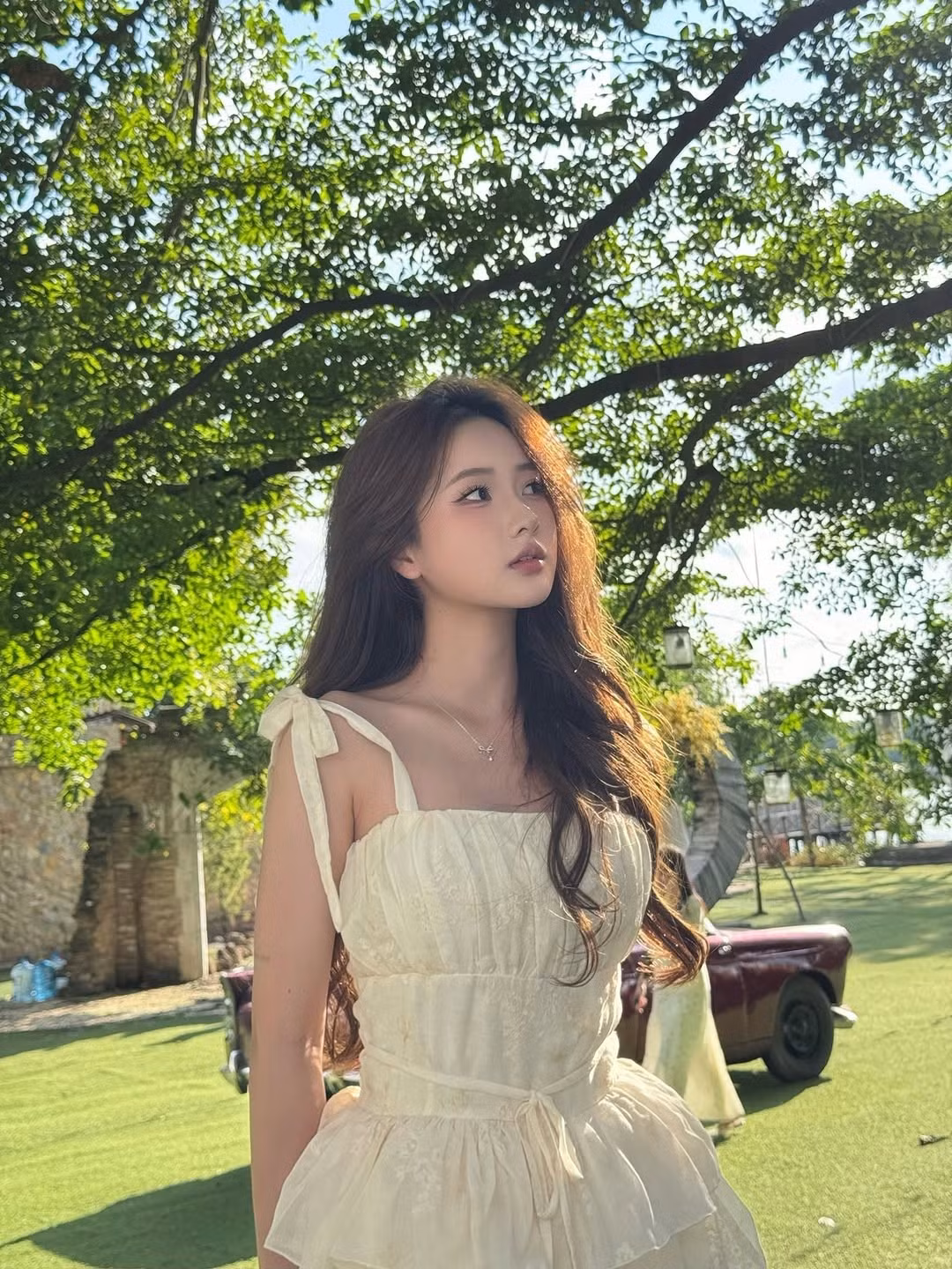 Từ khung cửa sổ cổ kính nhìn ra không gian xanh mát, đến những khoảnh khắc dưới tán cây rợp bóng hay trong không gian nội thất ấm áp, mọi góc hình đều tôn lên vẻ đẹp trong sáng và dịu dàng của cô.