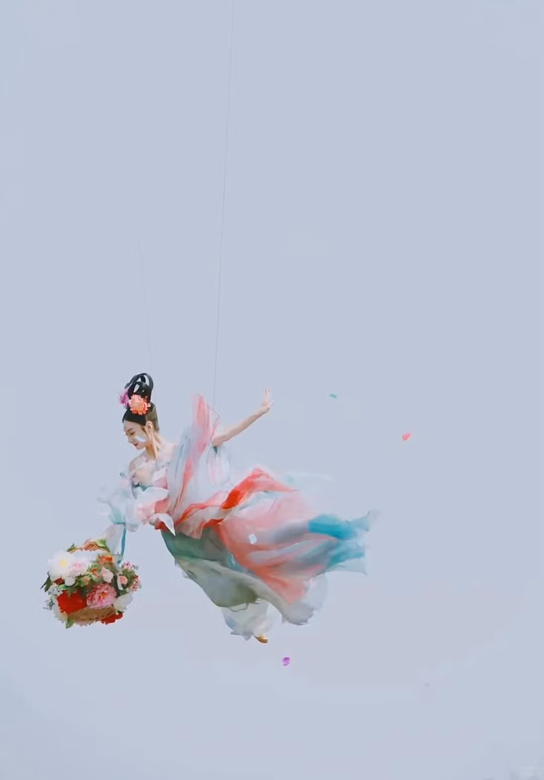 Theo nhịp nhạc, cô xoay tròn, tung hoa, khiến từng cánh hoa rơi lả tả như tuyết phủ, biến toàn bộ sân khấu thành một cõi tiên lung linh huyền ảo.