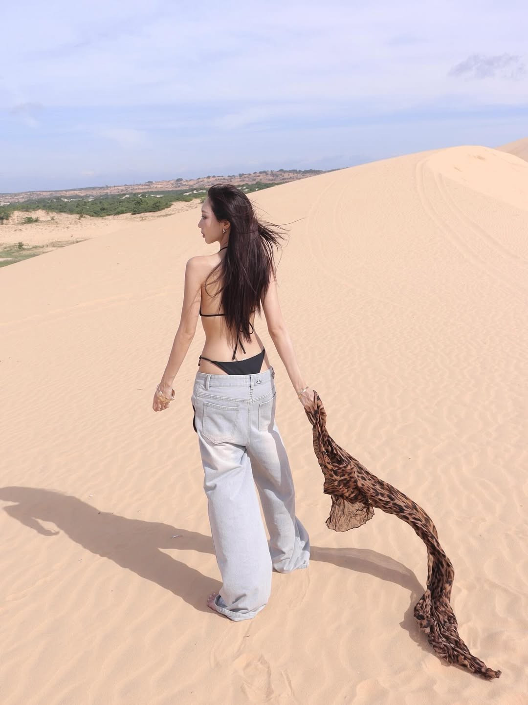 Cô nàng kết hợp bikini với chiếc quần jeans cạp trễ, ống rộng và táo bạo kéo khóa hờ hững, tạo nên một sự tương phản thú vị giữa nét nữ tính của bikini và sự bụi bặm của denim. (Ảnh: IGNV)