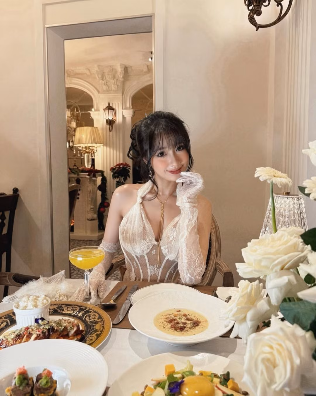 Trong bộ ảnh mới, hot TikToker xuất hiện tại một không gian nhà hàng sang trọng, lãng mạn. Cô chọn cho mình một chiếc đầm dài được làm từ chất liệu ren trắng mỏng manh, thiết kế theo phong cách xuyên thấu đầy mê hoặc.(Ảnh: IGNV)