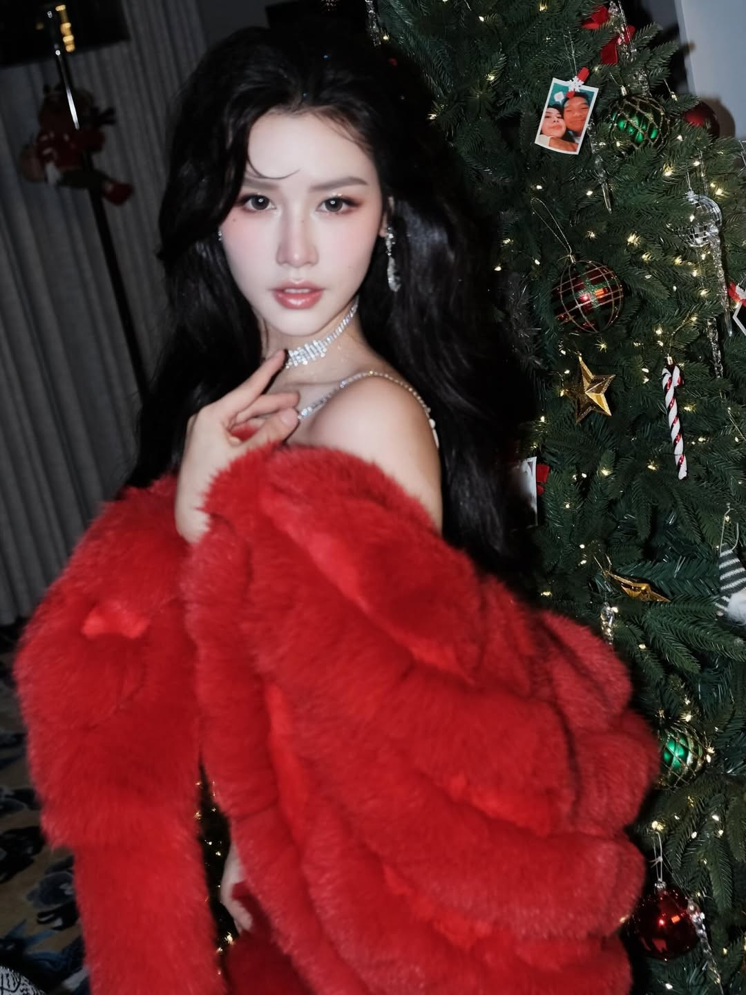 Điểm nhấn đắt giá nhất chính là chiếc áo khoác lông màu đỏ rực rỡ, vừa tạo cảm giác ấm áp đặc trưng của mùa lễ hội, vừa tôn lên làn da trắng sứ không tì vết. (Ảnh: IGNV)