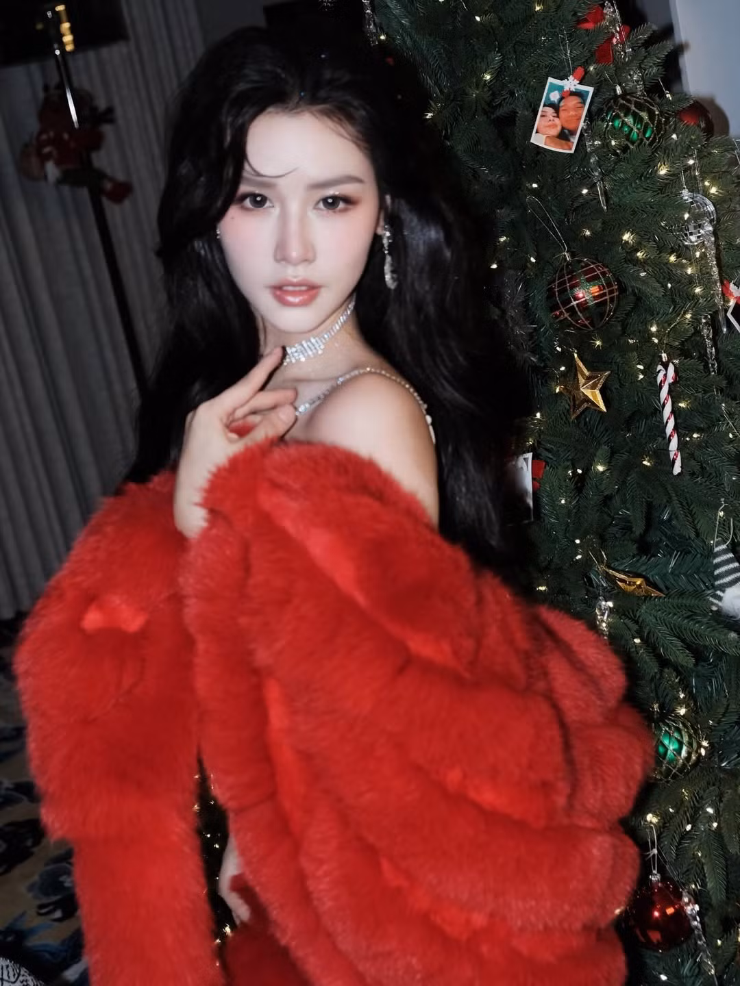 Điểm nhấn đắt giá nhất chính là chiếc áo khoác lông màu đỏ rực rỡ, vừa tạo cảm giác ấm áp đặc trưng của mùa lễ hội, vừa tôn lên làn da trắng sứ không tì vết. (Ảnh: IGNV)