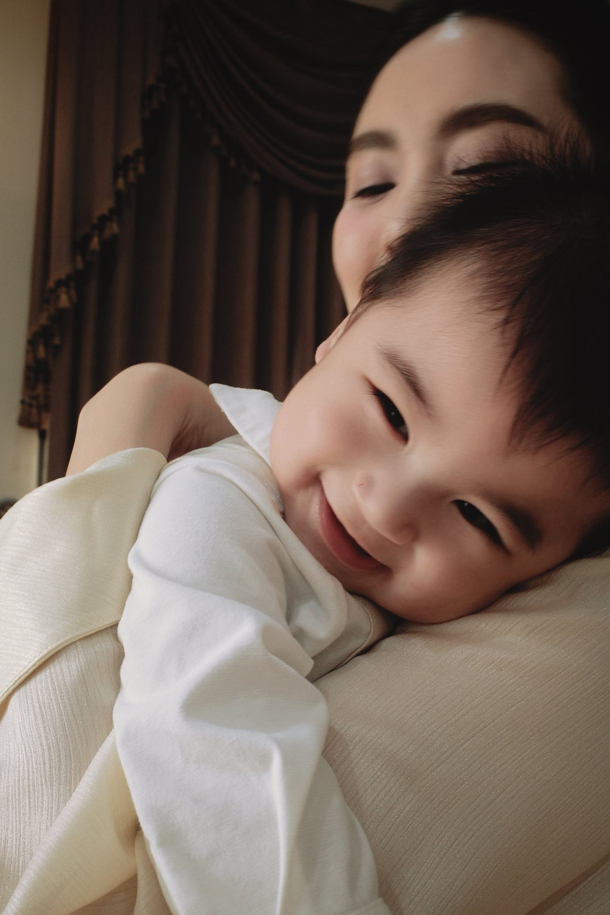 Điểm nhấn chiếm trọn "spotlight" trong loạt ảnh chính là sự xuất hiện của bé Panda. Cậu bé với đôi mắt to tròn, vẻ mặt lém lỉnh và mái tóc "tơ" dựng đứng khiến cư dân mạng tan chảy. Trong những khung hình cận cảnh, thiên thần nhỏ diện bộ đồ lịch lãm với chiếc nơ nhỏ thắt ở cổ, không ngần ngại cười đùa và nép vào lòng Mai Ngọc. (Ảnh: FBNV)