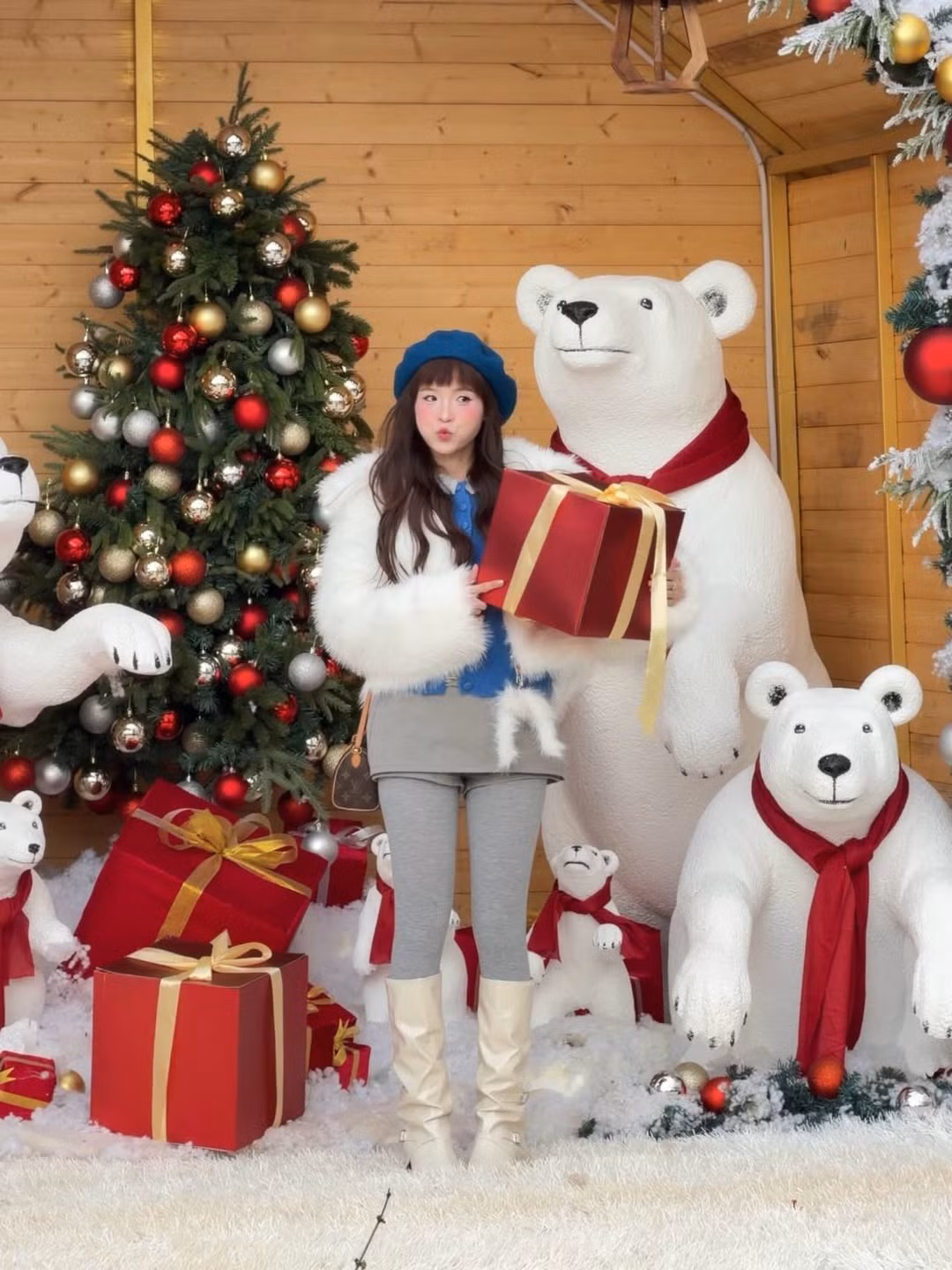 Cô kết hợp chiếc áo khoác lông trắng xù mềm mại, một chiếc áo len màu xanh dương nổi bật, chân váy xám ngắn cùng quần legging đồng màu, và đôi boots cao cổ màu kem. (Ảnh: IGNV)