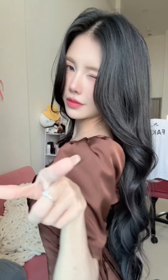 Bên cạnh tâm điểm chính là Mai Dora, các "thánh soi" của cộng đồng Esports còn nhanh chóng phát hiện ra một chi tiết thú vị ở góc phòng. Đó chính là chiếc áo thi đấu có in tên "FAKER" - huyền thoại sống của làng LMHT thế giới - đang được treo ngay phía sau lưng cô. (Ảnh: IGNV)