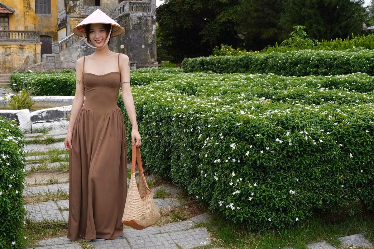 Giữa khung cảnh xanh mướt của những vườn cây được cắt tỉa công phu và kiến trúc cổ kính đặc trưng của Huế, Hiền Anh Bông như hóa thân thành một thiếu nữ xưa bước ra từ tranh vẽ.