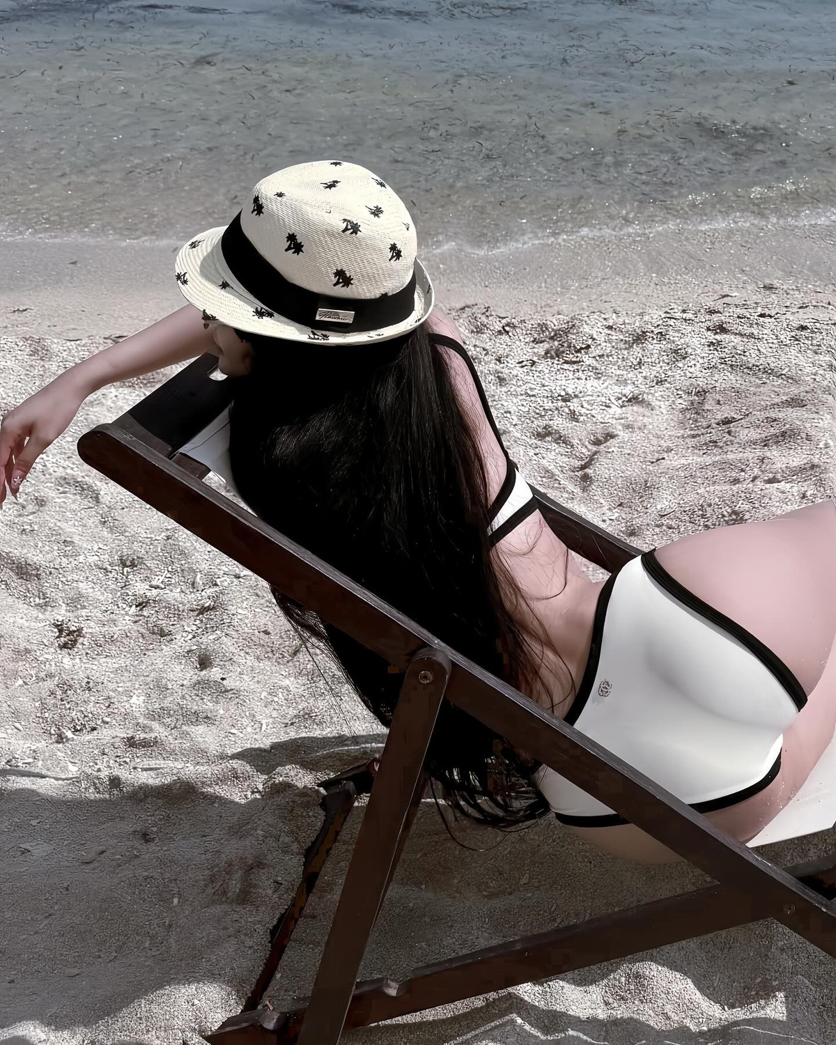 Không dừng lại ở đó, cô nàng tiếp tục đốt mắt người xem với những khoảnh khắc nằm thư giãn trên ghế dài trong bộ bikini trắng - đen tối giản nhưng vẫn đầy cuốn hút.