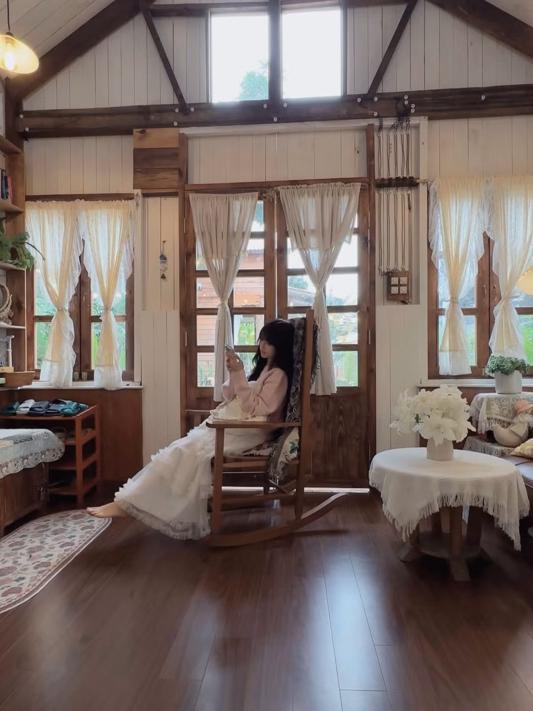 Cô nàng lựa chọn trang phục mang tông màu hồng - trắng chủ đạo: chiếc áo len hồng phấn mềm mại kết hợp cùng chân váy voan tầng bồng bềnh. Sự kết hợp này không chỉ tôn lên làn da trắng sứ mà còn cực kỳ ăn nhập với sắc hoa mai anh đào dịu dàng. (Ảnh: IGNV)