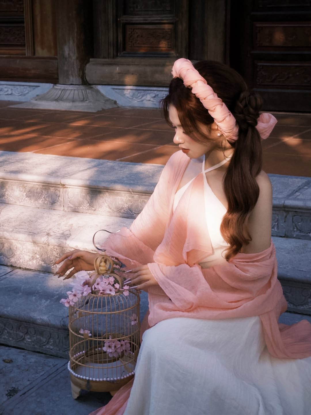 Đôi mắt to tròn có hồn cùng làn da trắng mịn màng giúp cô nàng tỏa sáng trong những khung hình cận mặt. Lê Na sở hữu "góc nghiêng thần thánh" với sống mũi cao thẳng và xương quai hàm thanh thoát, vẻ đẹp này được tôn vinh tuyệt đối khi cô nàng tạo dáng bên chiếc dù giấy hay lồng chim. (Ảnh: IGNV)