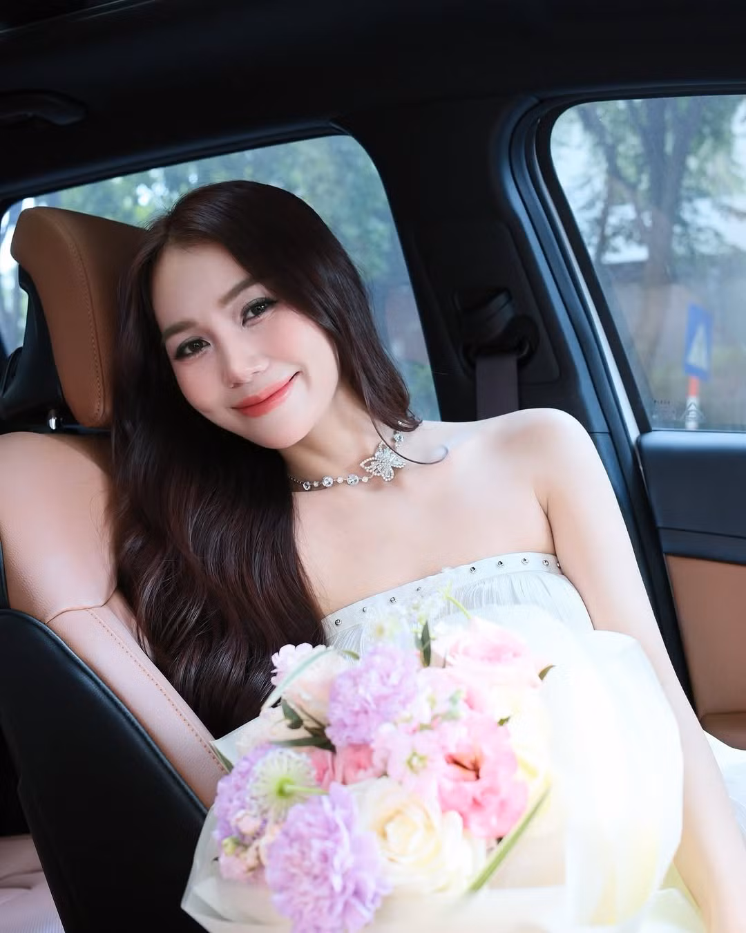 Vẻ dịu dàng được tôn lên nhờ lối trang điểm tự nhiên, mái tóc dài uốn lượn buông xõa càng làm nổi bật nét nữ tính và thanh thoát của cô. Chiếc vòng cổ với điểm nhấn hình bướm lấp lánh như “nốt nhạc” hoàn hảo tôn lên sự thanh lịch và đẳng cấp.