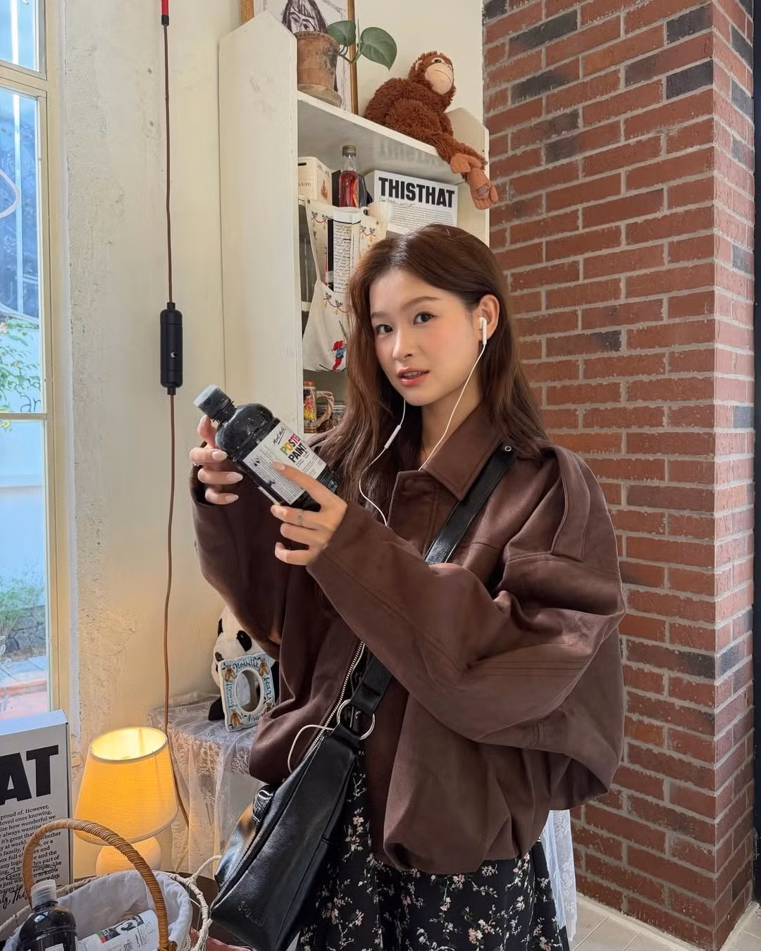 Cô nàng mix cùng một chiếc váy hoa nhí tối màu, giúp cân bằng lại sự cứng cáp của chiếc áo khoác. (Ảnh: IGNV)