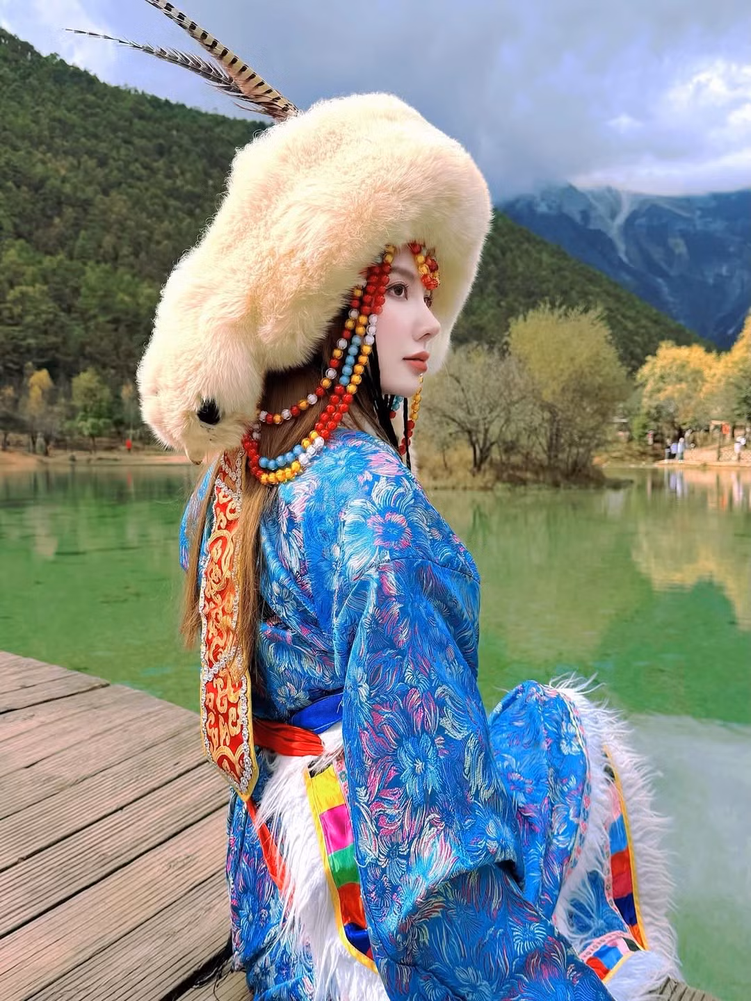 Khung cảnh Lam Nguyệt Cốc với màu nước hồ xanh ngọc bích trong vắt, kết hợp cùng những ngọn núi phủ mây mờ và thảm thực vật xanh tươi đã tạo nên một phông nền điện ảnh, hoàn toàn ăn khớp với bộ trang phục mang hơi hướng cổ điển. (Ảnh: IGNV)