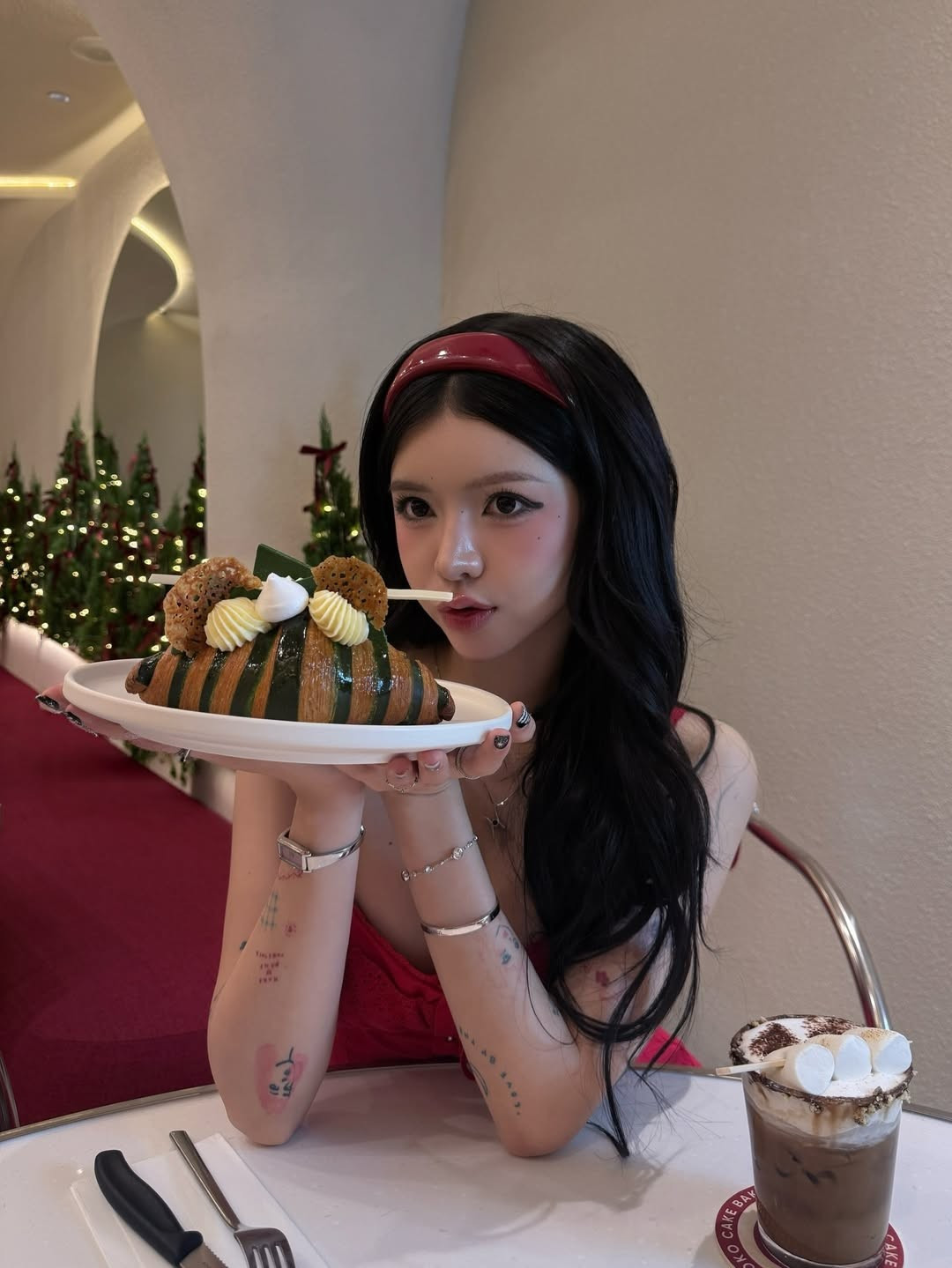 Lấy bối cảnh tại một quán cafe được trang trí lộng lẫy với những hàng thông xanh mướt và ruy băng đỏ, CiiN trông giống như một "nàng công chúa tuyết" hiện đại. (Ảnh: IGNV)