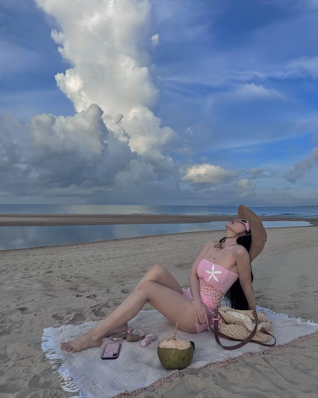 Không dừng lại ở đó, Sĩ Thanh hoàn thiện tổng thể bằng phụ kiện cá tính như kính râm bản to, vòng cổ handmade túi cói tone nâu be – tạo nên phong cách beachwear đầy phóng khoáng và thời thượng.