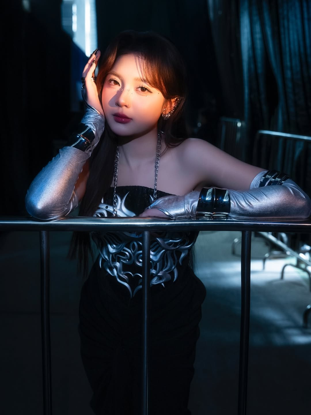 Cô diện chiếc váy dạ hội dài màu đen tuyền, được thiết kế xẻ tà tinh tế, kết hợp với phần corset cúp ngực ấn tượng. Điểm nhấn mạnh mẽ nhất là họa tiết kim loại bạc với tạo hình như một chiếc giáp ngực mang hơi hướng thần thoại, ôm trọn phần thân trên. (Ảnh: IGNV)