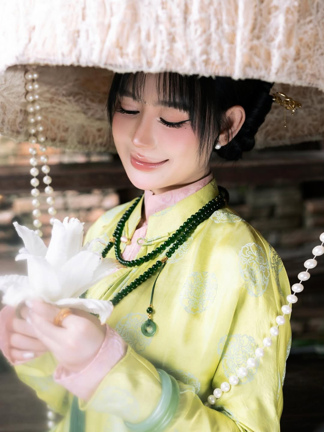 Trong bộ ảnh này, Vân Tiny lựa chọn thiết kế mang phong cách của những tiểu thư khuê các thời xưa với tông màu xanh cốm dịu mắt, điểm xuyết những họa tiết gấm chìm sang trọng. Bên cạnh đó, nàng hot girl khéo léo sử dụng chuỗi hạt đá xanh lục bảo, vòng ngọc cẩm thạch và trâm cài tóc vàng để hoàn thiện vẻ ngoài vương giả. (Ảnh: IGNV)