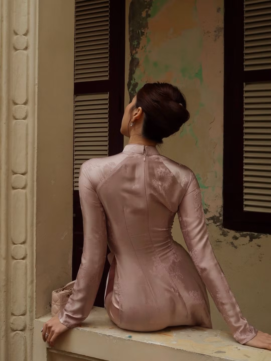 Bộ ảnh đưa người xem đi qua những địa điểm mang đậm dấu ấn thời gian: từ cửa hiệu thuốc đông y cổ kính trên phố Lãn Ông, những mảng tường vàng đặc trưng của phố cổ, cho đến không gian nội thất gỗ chạm trổ cầu kỳ với những bình hoa đào rực rỡ. (Ảnh: IGNV)