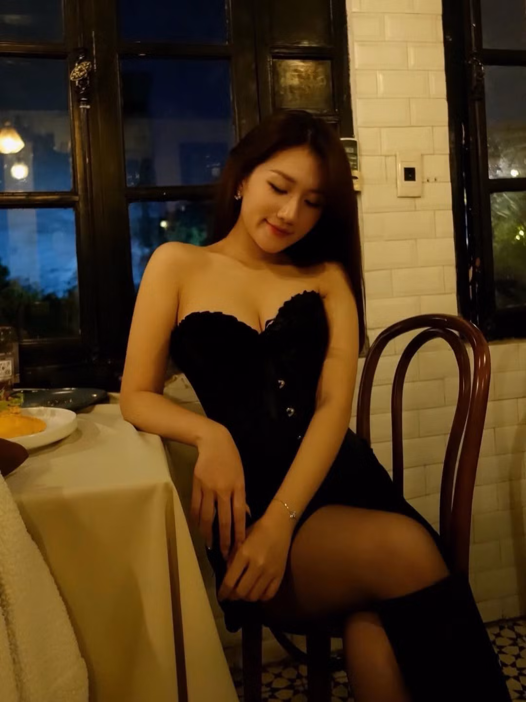 Trong không gian ấm cúng với ánh đèn vàng và nến, MC Linh Nắng tạo dáng yêu kiều đầy cuốn hút.