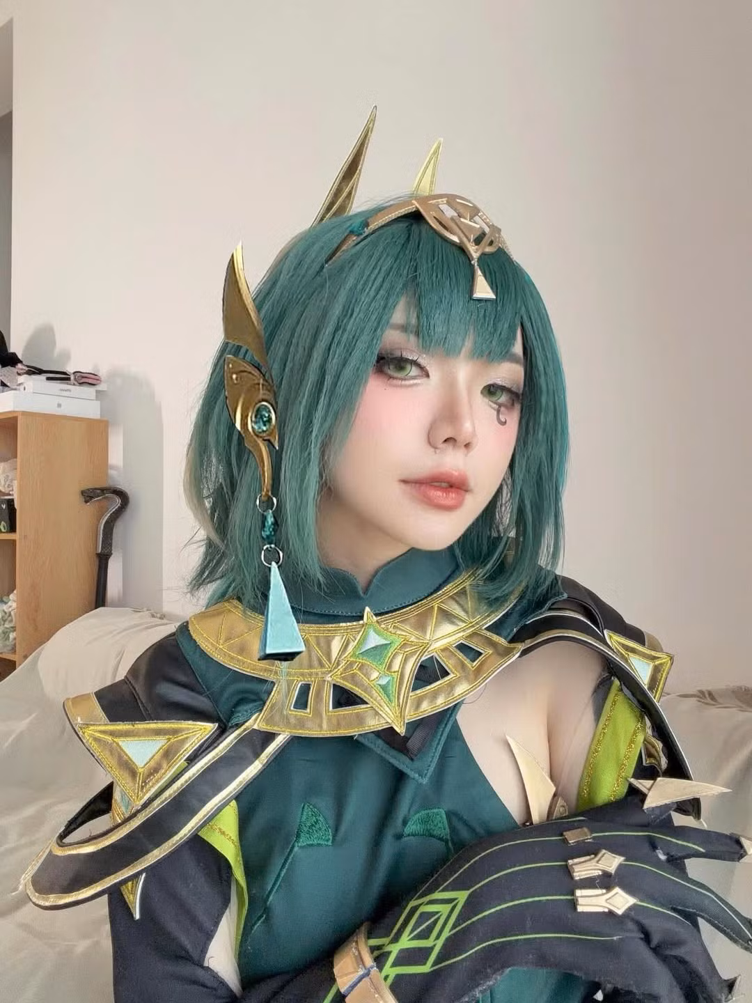 Mái tóc bob màu xanh ngọc bích nổi bật, cùng với lối trang điểm sắc sảo, nhấn mạnh vào đôi mắt xanh và vết vẽ độc đáo dưới mắt đã làm nổi bật khí chất vừa bí ẩn vừa quyền lực của nhân vật. (Ảnh: IGNV)