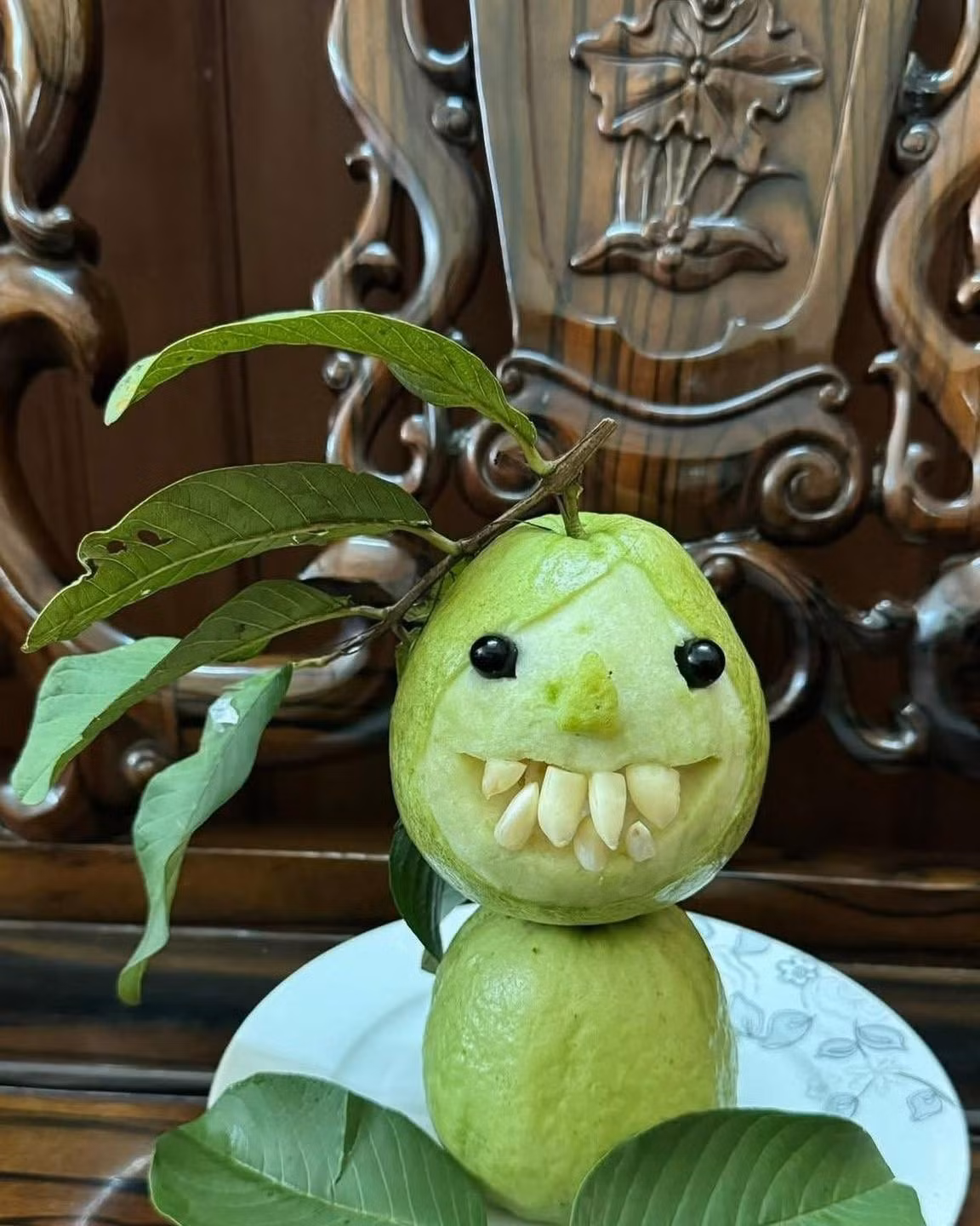 Quả ổi xanh có hình dáng đầu người được tạo hình với chiếc mũi nhọn và hàm răng nanh to, sắc lẹm, mang đậm phong cách của những nhân vật phản diện trong phim kinh dị. (Ảnh: FB Phạm Chuyên)