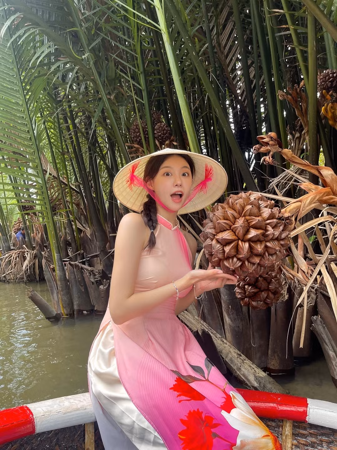 Cô diện chiếc áo dài được thiết kế cách điệu với phần cổ yếm màu hồng nhạt, ôm sát cơ thể với phần tà in họa tiết hoa lớn nổi bật. Chiếc áo dài này không chỉ tôn lên vóc dáng thanh thoát mà còn làm nổi bật vẻ dịu dàng, nữ tính của cô. (Ảnh: IGNV)