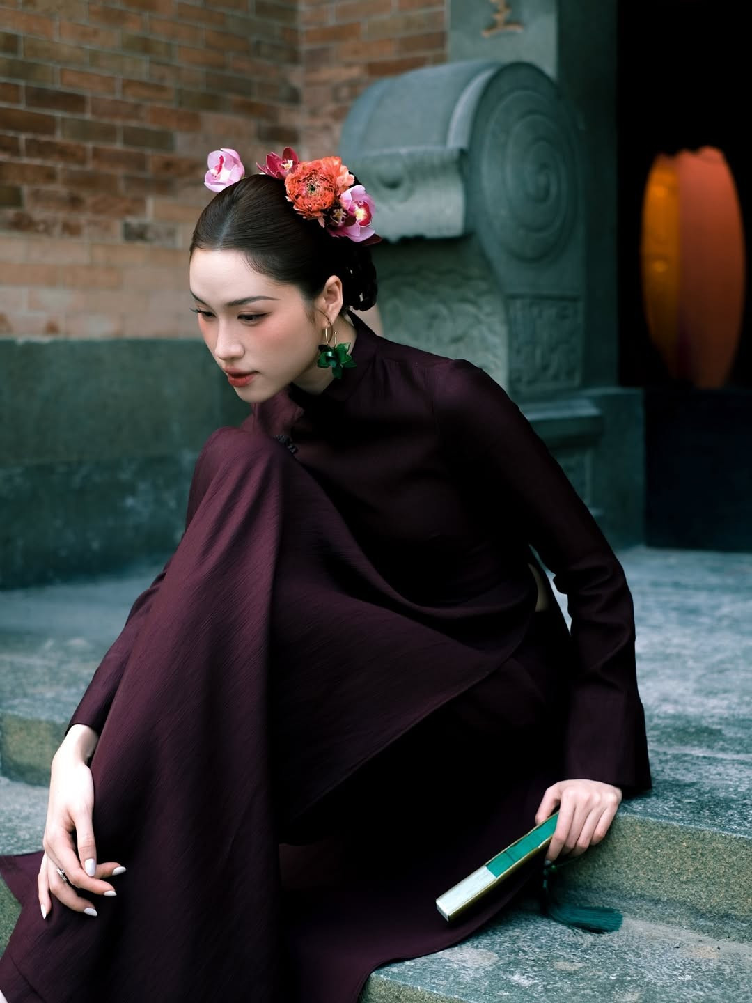 Kết hợp cùng tà áo dài, người đẹp sử dụng phụ kiện là quạt xếp cầm tay màu xanh lá nổi bật, tạo điểm nhấn thú vị cho tổng thể bức ảnh. (Ảnh: IGNV)