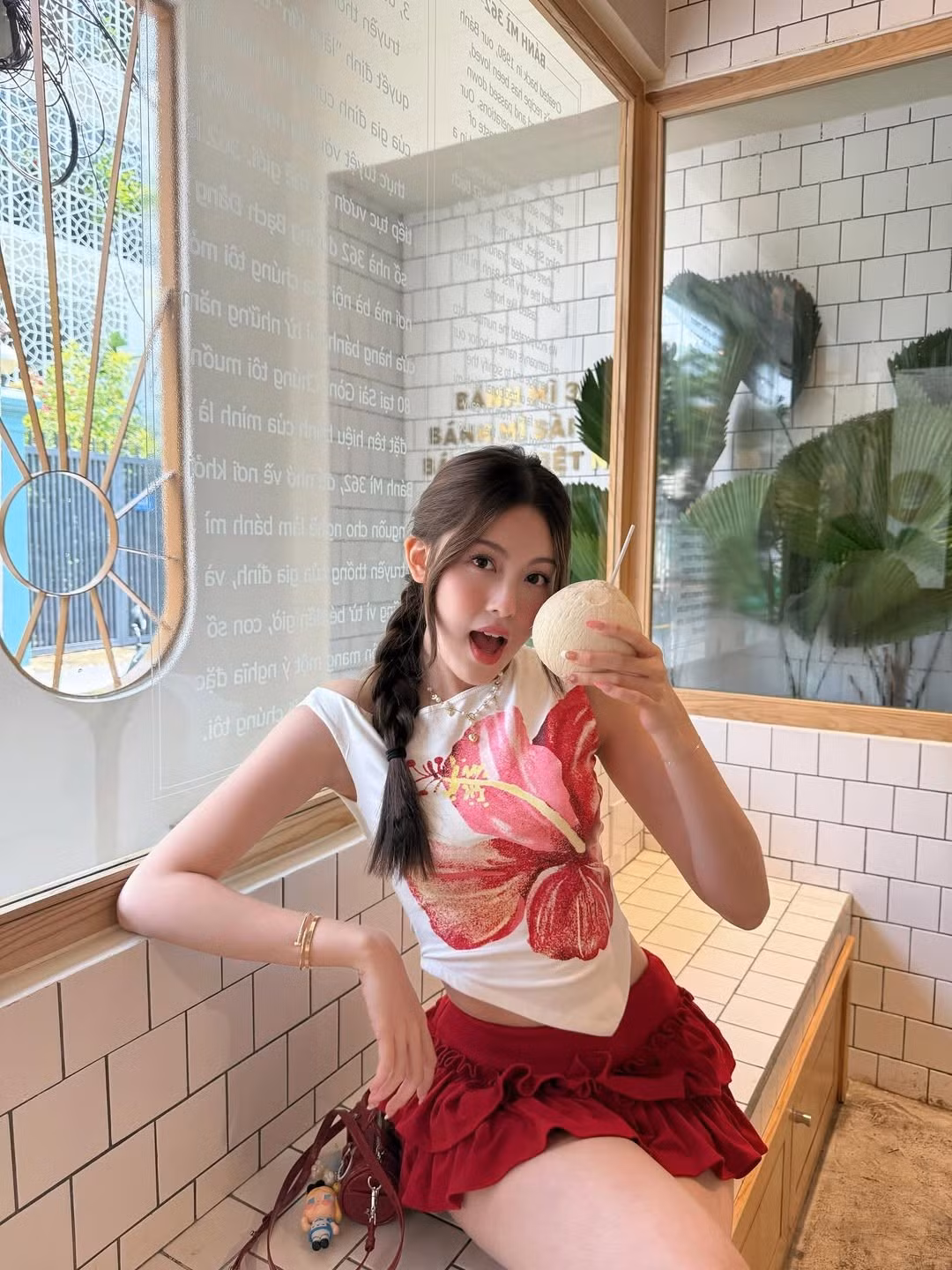 Chiếc áo này được phối cùng chân váy ngắn xếp tầng màu đỏ rực rỡ, tạo nên một tổng thể vừa năng động, vừa nữ tính, rất "hợp cạ" với không khí mùa hè.