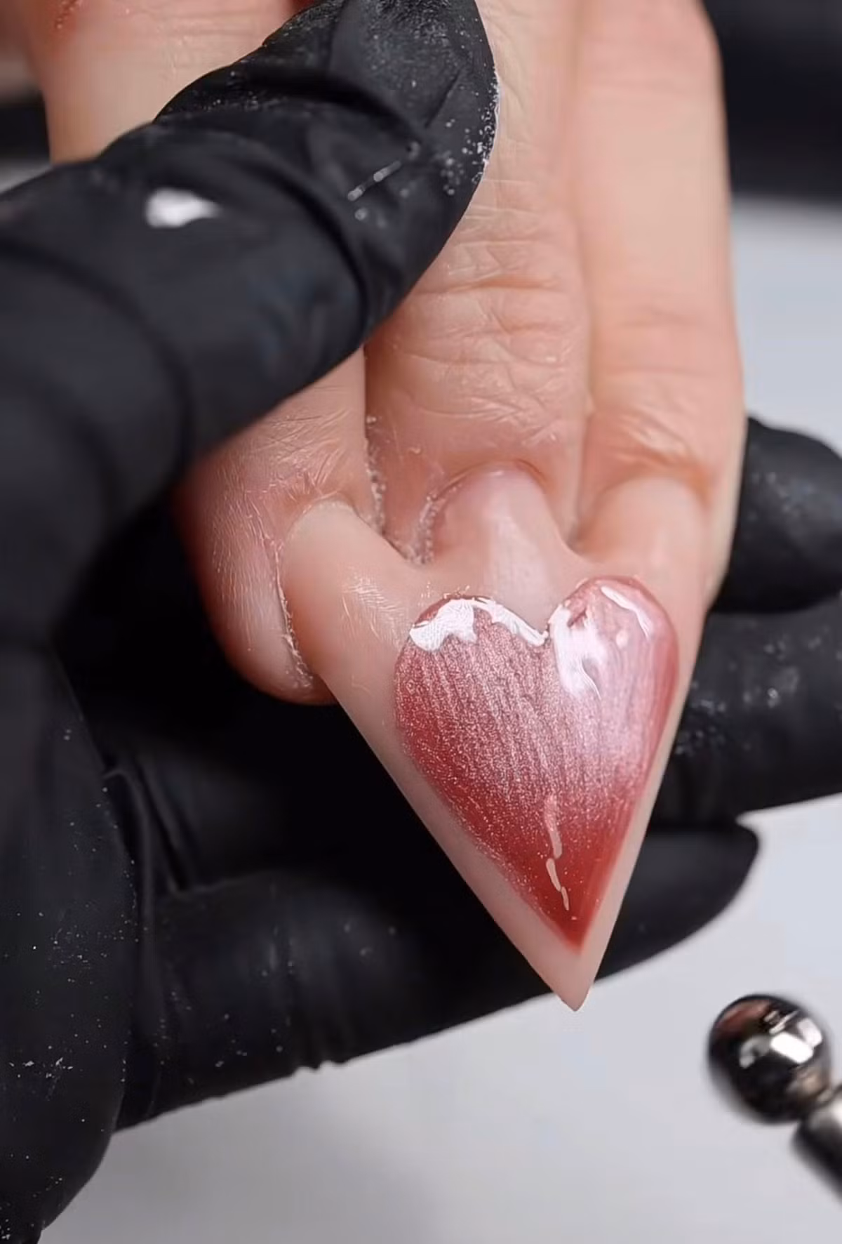 Để tăng thêm phần lộng lẫy, bộ móng được phủ một lớp sơn hồng thạch bóng loáng và viền vàng kim 3D.