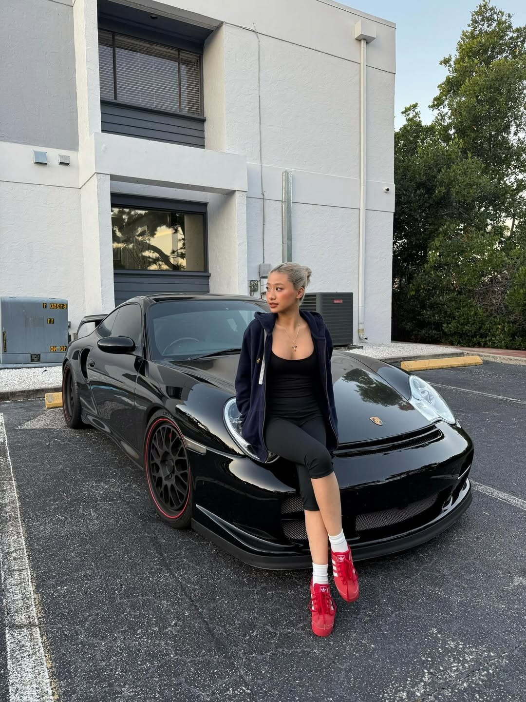 Gây ấn tượng mạnh nhất là khoảnh khắc Louis Phạm tạo dáng đầy thần thái bên chiếc Porsche thể thao màu đen hầm hố, cô tạo dáng nửa ngồi nửa tựa trên nắp capo của chiếc xe. (Ảnh: IGNV)