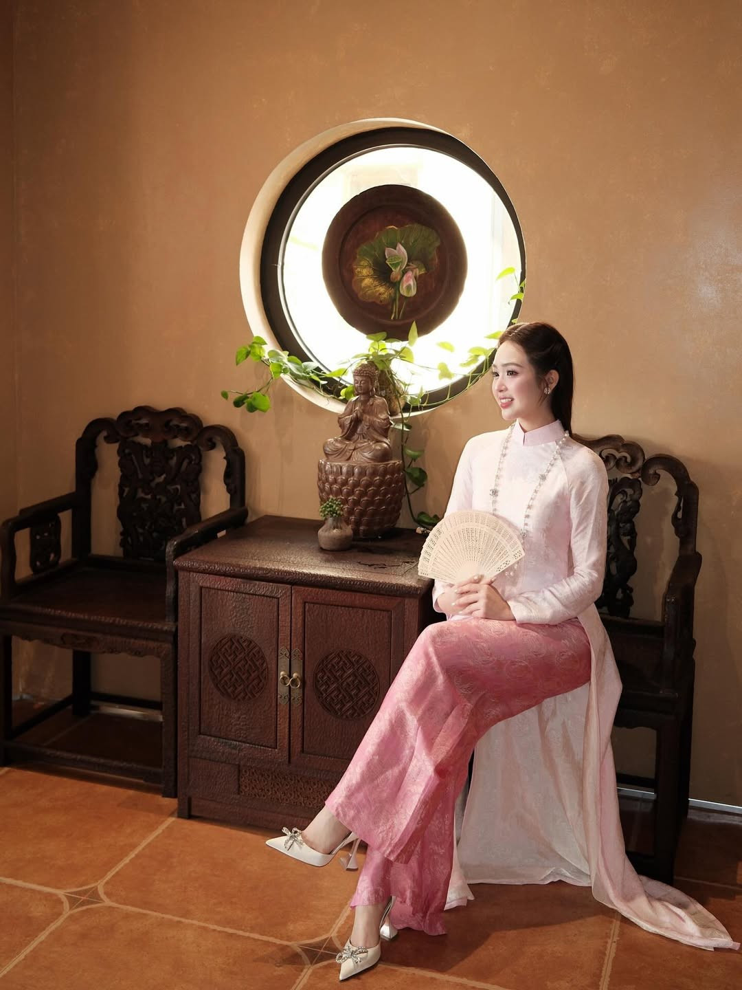 Cô khéo léo kết hợp cùng chuỗi vòng cổ ngọc trai dài, đôi bông tai đồng điệu và chiếc quạt giấy - những phụ kiện đặc trưng của phụ nữ Hà thành xưa, gợi lên nét đẹp của một "nàng thơ" khuê các. (Ảnh: IGNV)