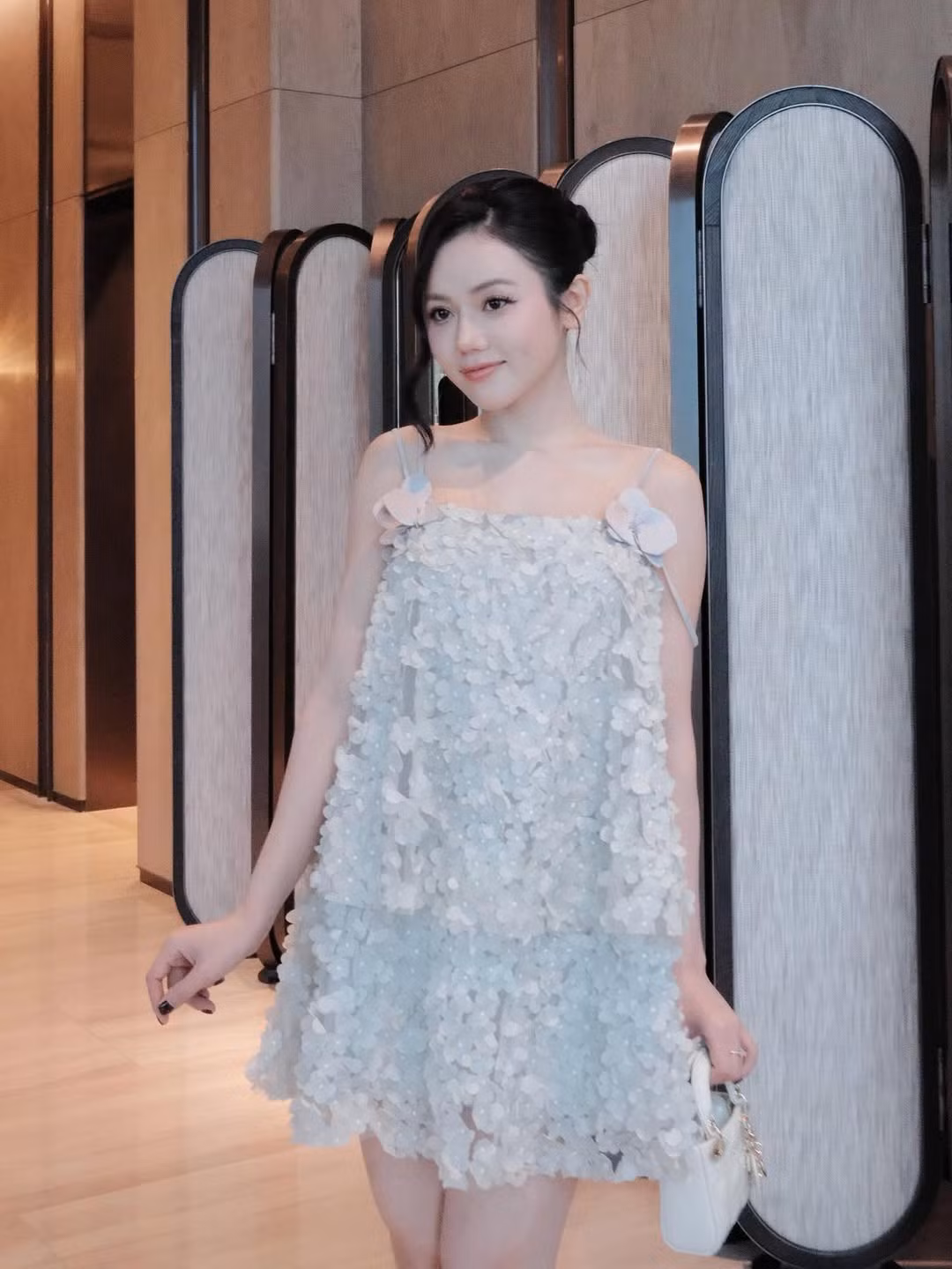 Cô nàng tạo dáng trong một không gian sang trọng với cửa kính lớn, nhìn ra toàn cảnh thành phố lung linh với những cây cầu và dòng sông.